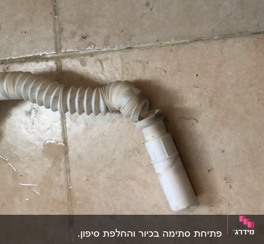 צינור פלסטיק גמיש עם חיבורי הברגה על רצפה רטובה